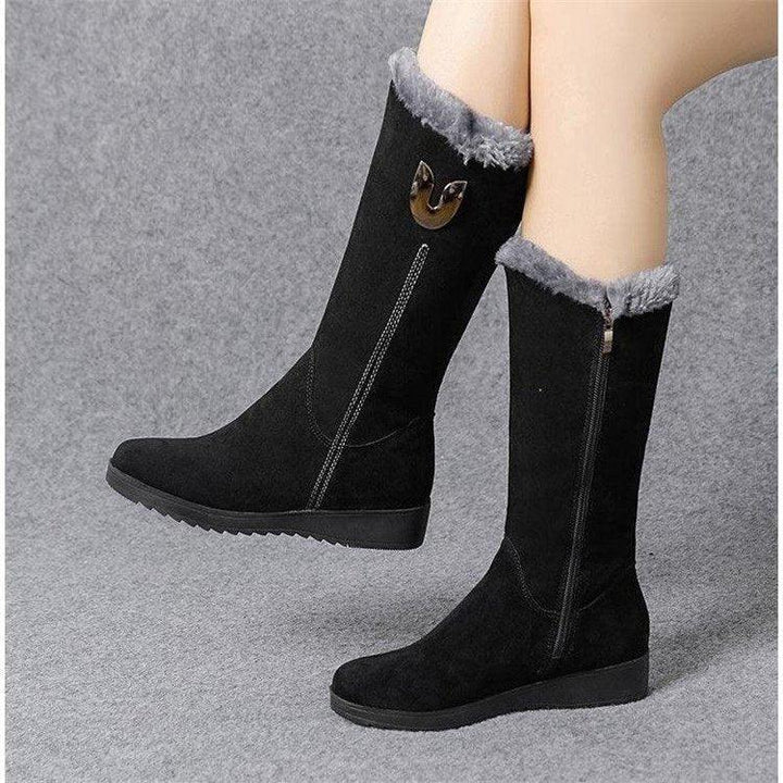 Black mid-calf winter boots with gray fur trim and side zipper on gray background