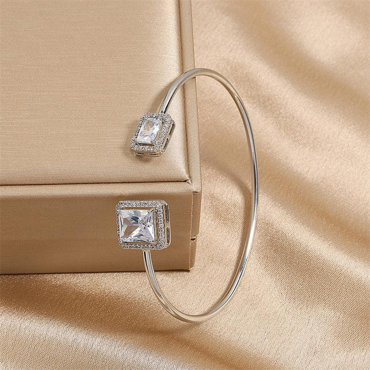 silver cuff bracelet with square crystal accents on beige satin fabric and gift box