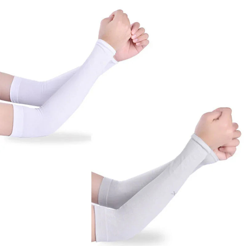 Pairs of white and light gray cooling arm sleeves worn on forearms with hands in fists
