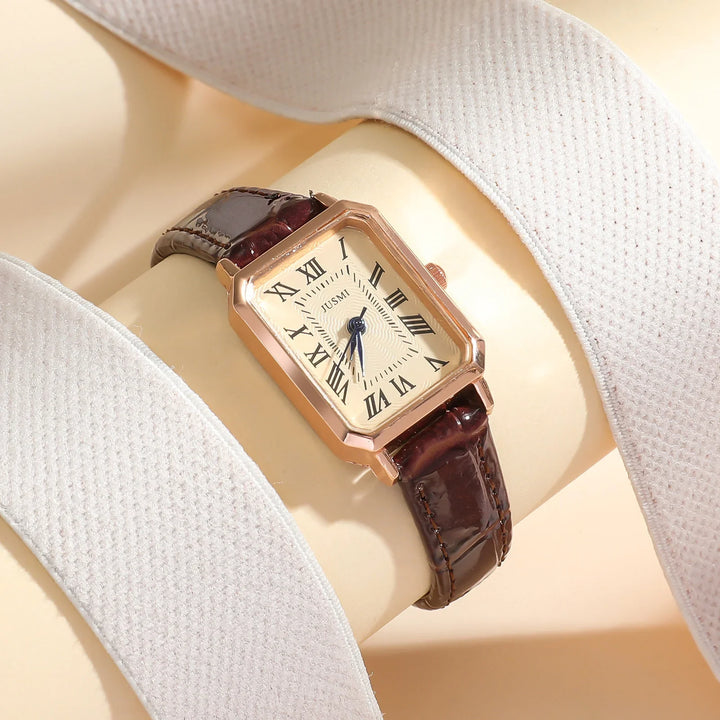 Rectangular gold wristwatch with brown leather strap and Roman numerals on dial