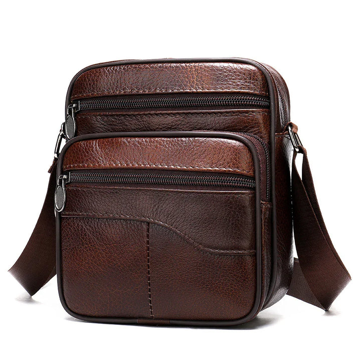 Brown leather crossbody bag with two zippered front pockets and adjustable strap