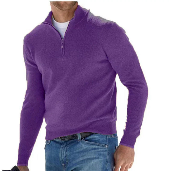 Man wearing a purple quarter-zip sweater over a white shirt with blue jeans