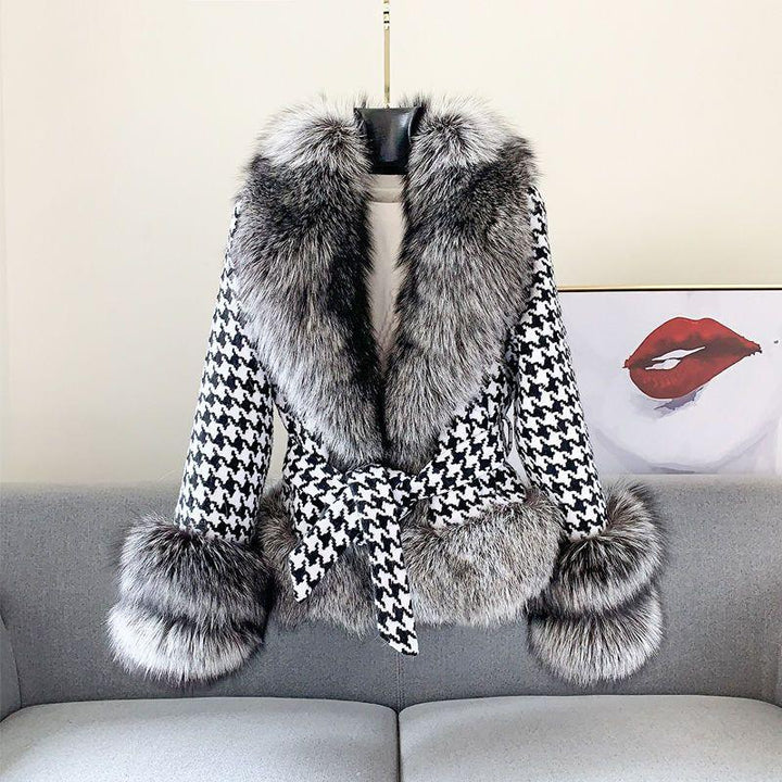 Stylish black and white houndstooth coat with thick gray fur collar, cuffs, and hem on gray couch