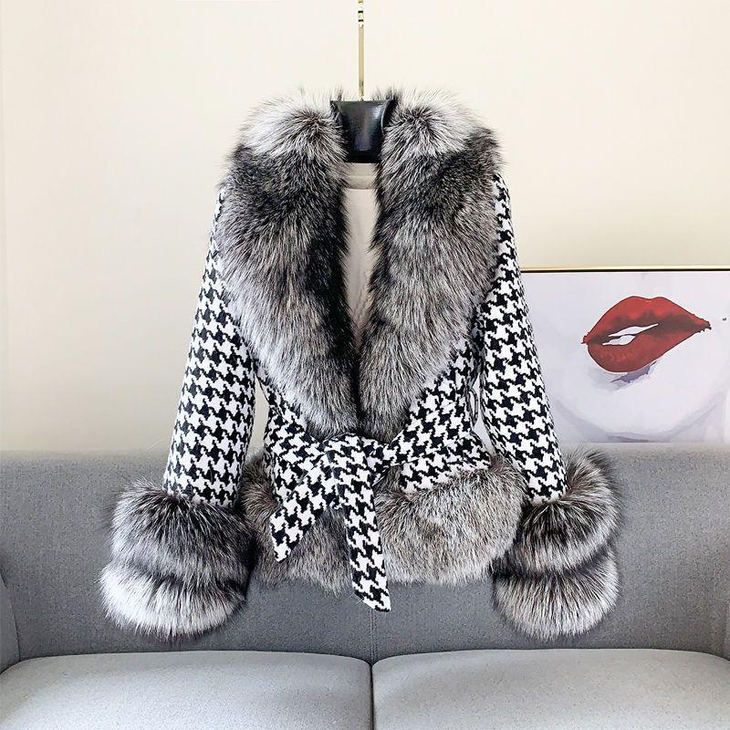 Black and white houndstooth coat with large gray faux fur collar and cuffs displayed on couch