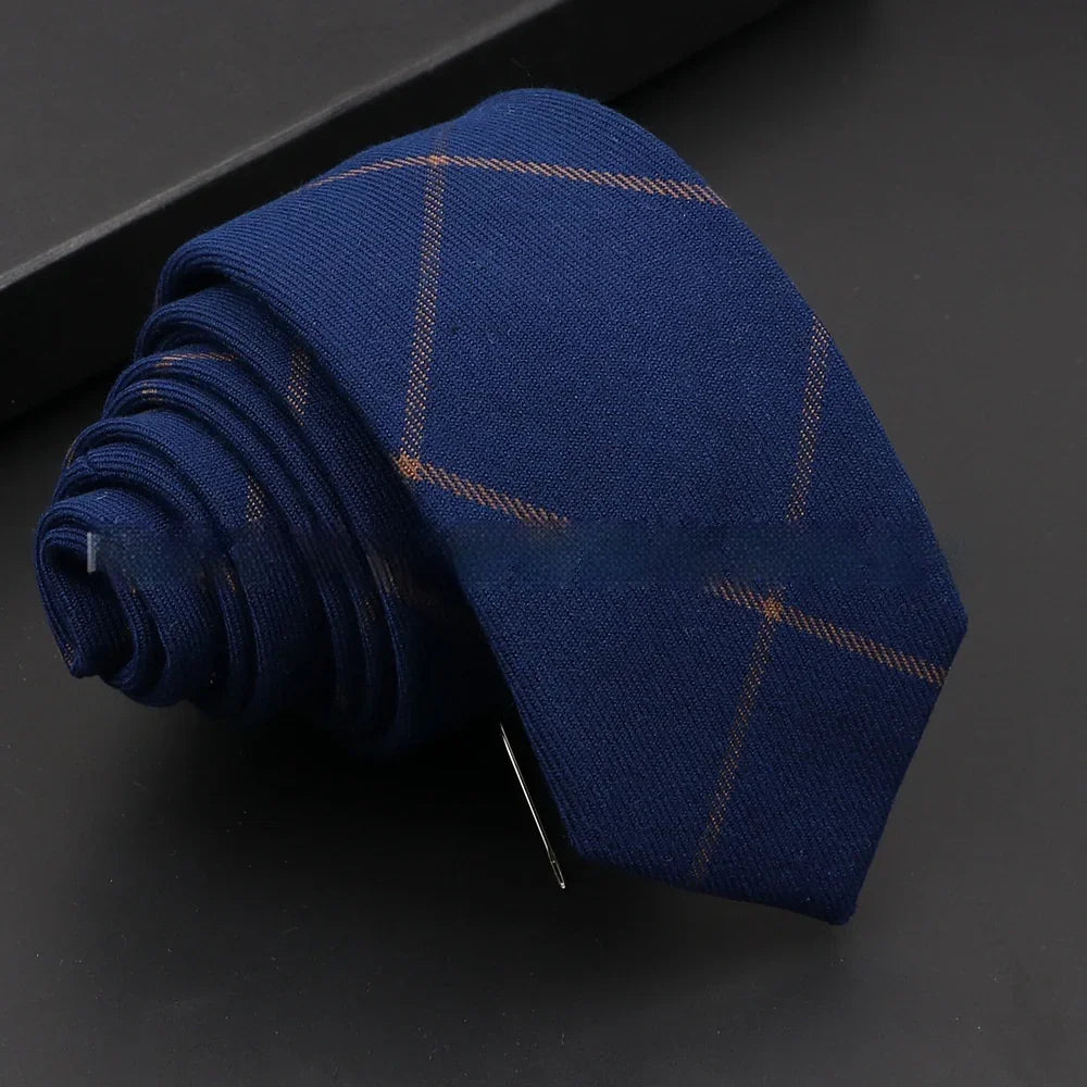 Rolled navy blue necktie with subtle brown windowpane pattern on black surface