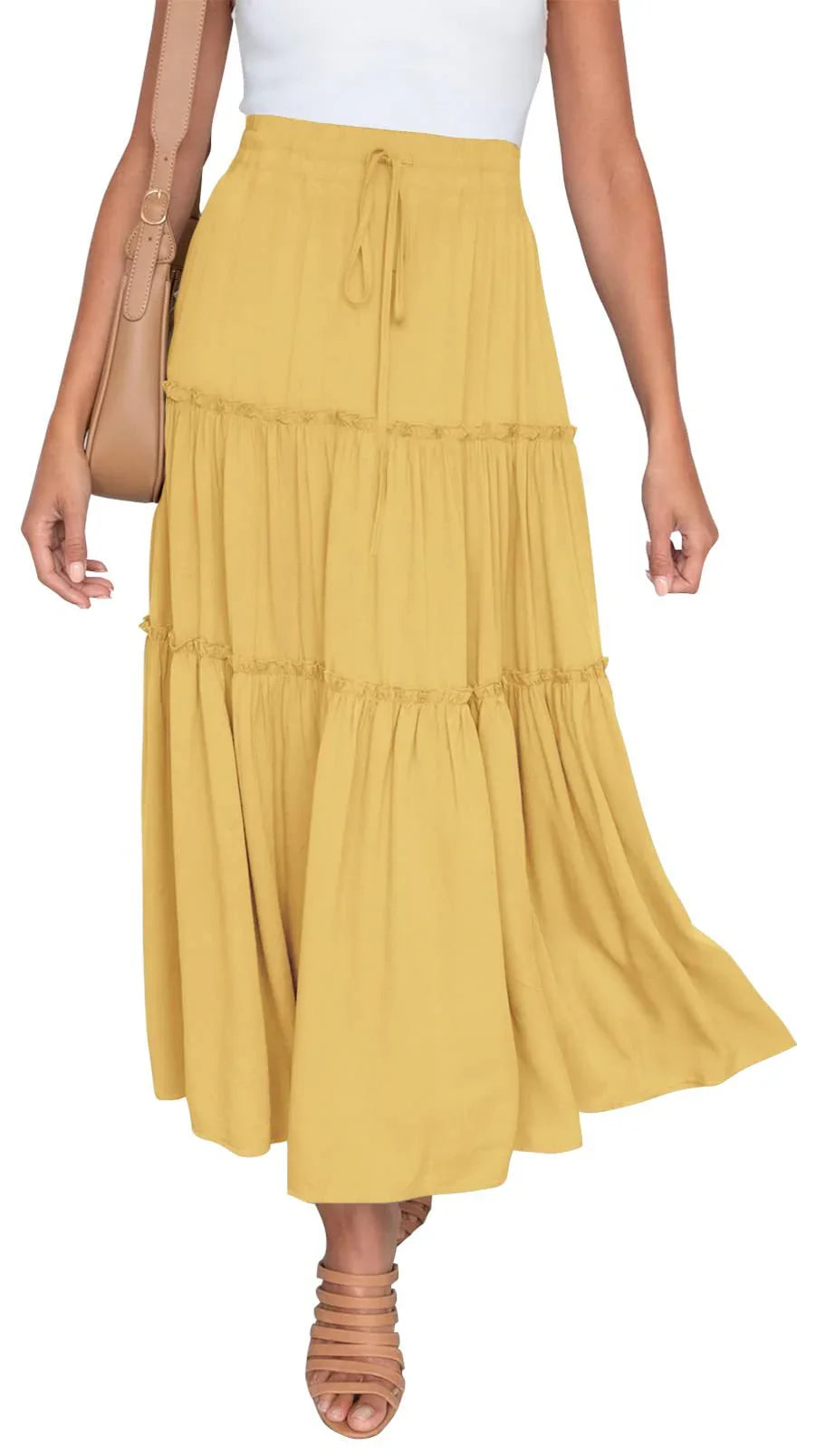 Woman wearing a mustard yellow tiered maxi skirt with drawstring waist and tan sandals