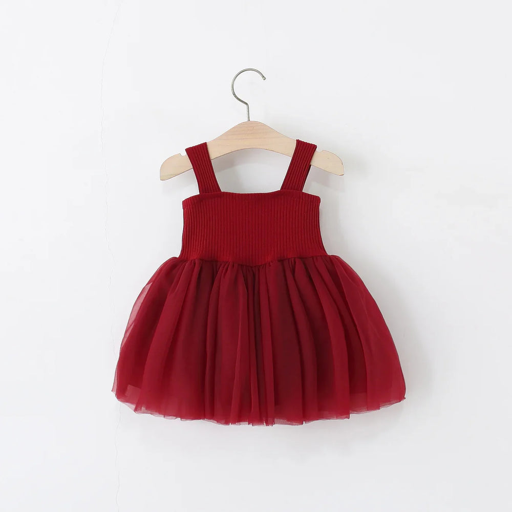 Red toddler dress with ribbed bodice and tulle skirt hanging on wooden hanger