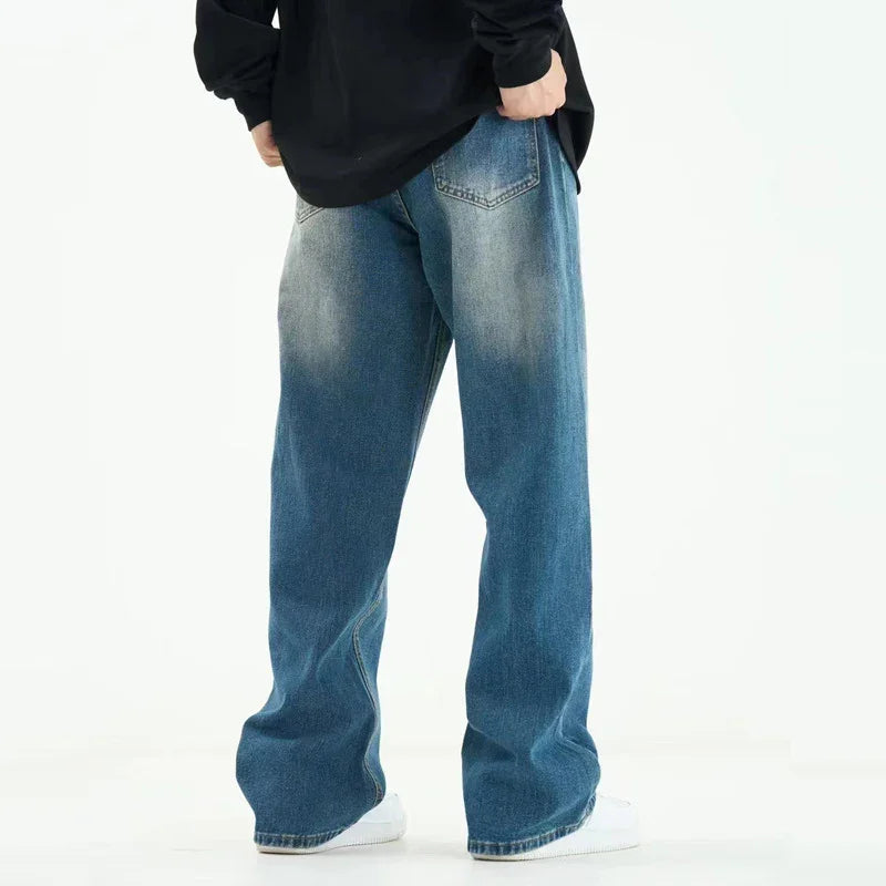Back view of person wearing loose fit faded blue denim jeans with a black top and white sneakers