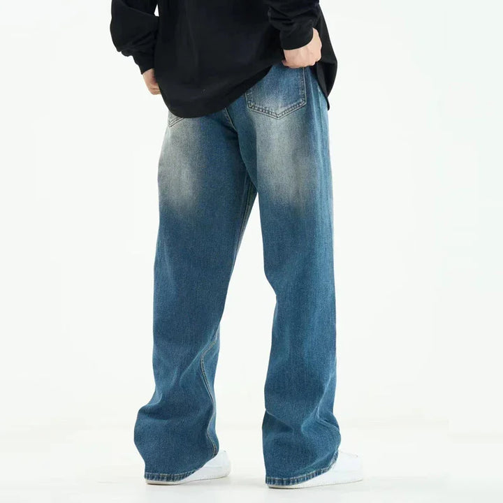 Back view of person wearing loose fit faded blue denim jeans with a black top and white sneakers