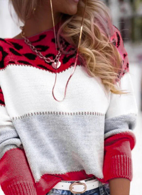 Woman wearing a red, white, and gray color block sweater with leopard print yoke and gold chain necklace