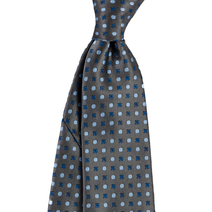 Grey silk necktie with blue polka dots and small cross patterns on white background