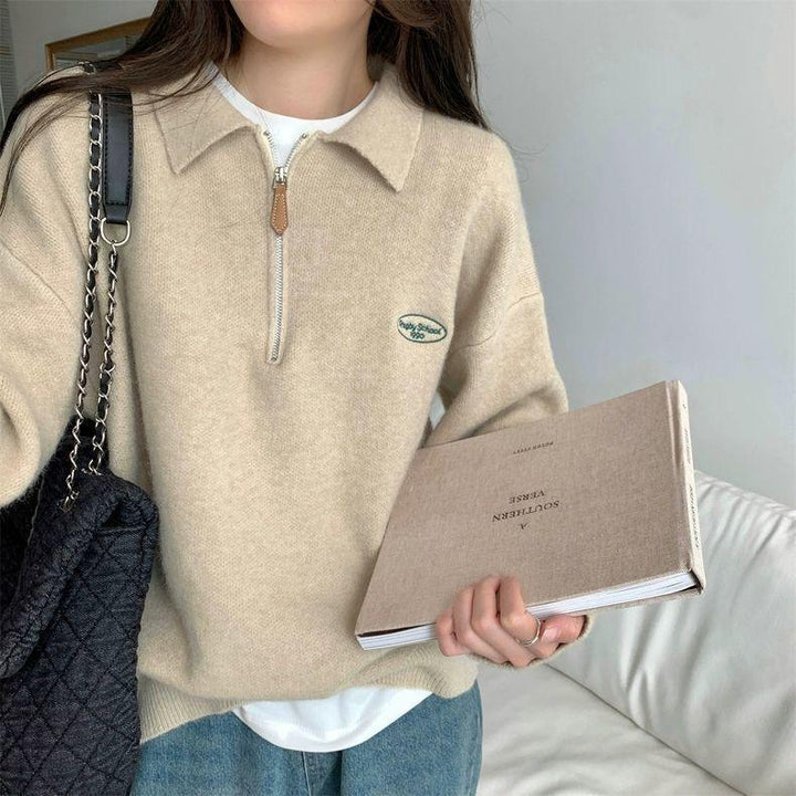 Woman wearing beige half-zip sweater with collar, holding book titled A Southern Verse, carrying black quilted handbag