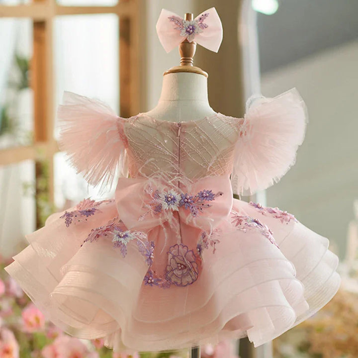 Pink toddler dress with floral embroidery, tulle puff sleeves, bow back, and matching hair bow
