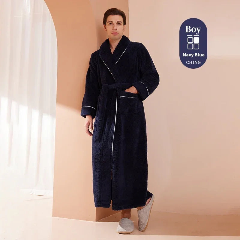 Man wearing navy blue plush bathrobe with white trim and gray slippers against beige wall