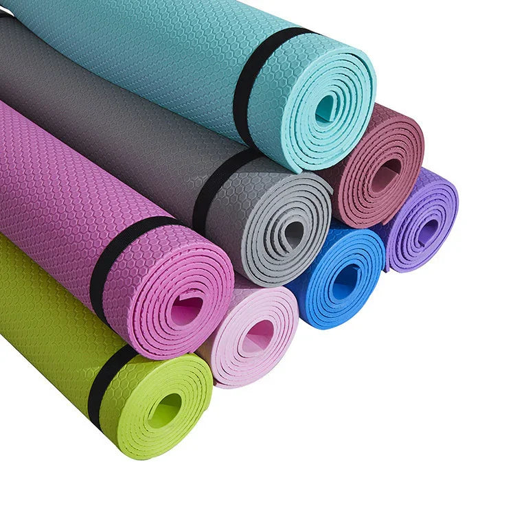 Colorful rolled yoga mats with textured surface stacked together on white background