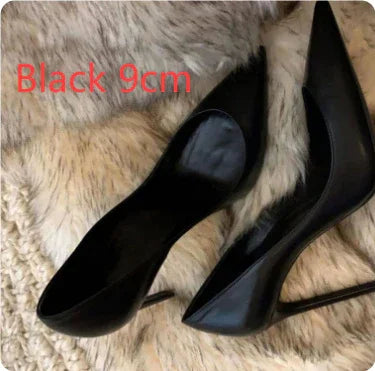 Pair of black 9cm high heel stiletto shoes on a textured beige fur surface