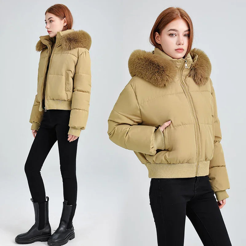 Young woman wearing beige puffer jacket with fur collar, black pants, and black boots on white background