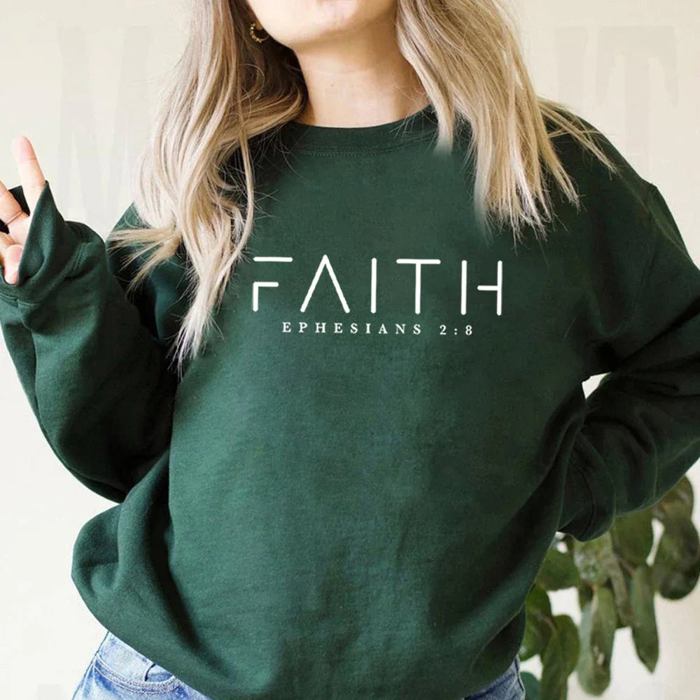 Woman wearing dark green sweatshirt with faith and Ephesians 2:8 Christian scripture text