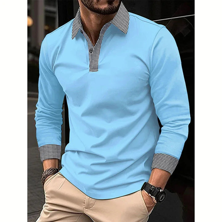 Man wearing light blue long sleeve polo shirt with black and white houndstooth collar and cuffs, beige pants