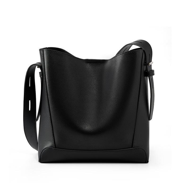 Black leather bucket bag with adjustable strap on white background