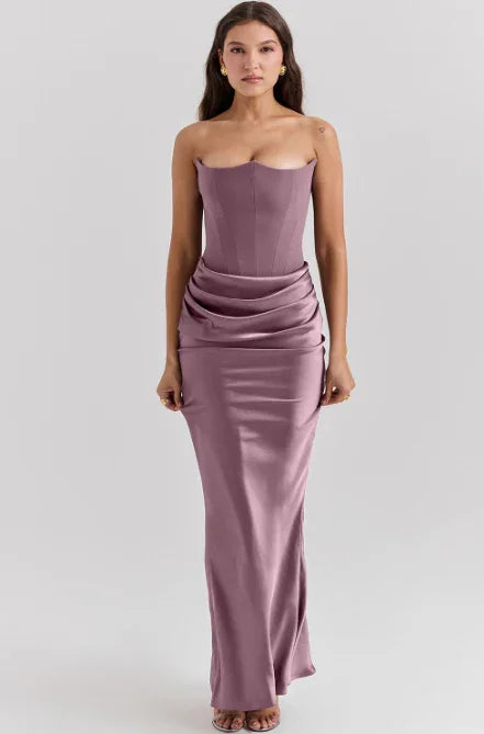 woman wearing strapless mauve satin evening gown with draped waist detail on gray background