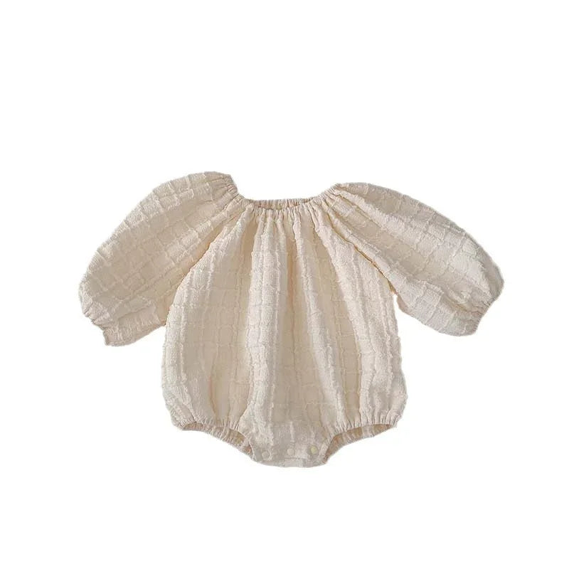 Cream textured long sleeve baby romper with elastic neckline and snap buttons