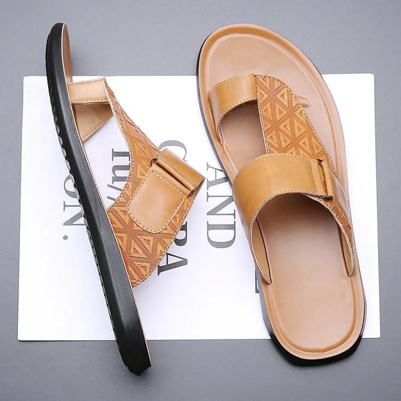 Tan leather men's sandals with geometric strap pattern and black sole on gray background