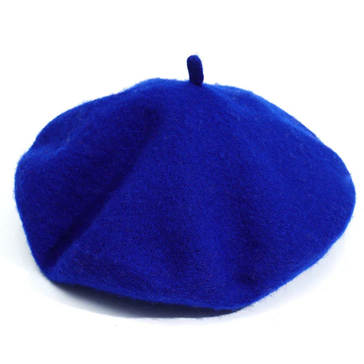 Bright royal blue wool beret hat with classic small top stem on white background