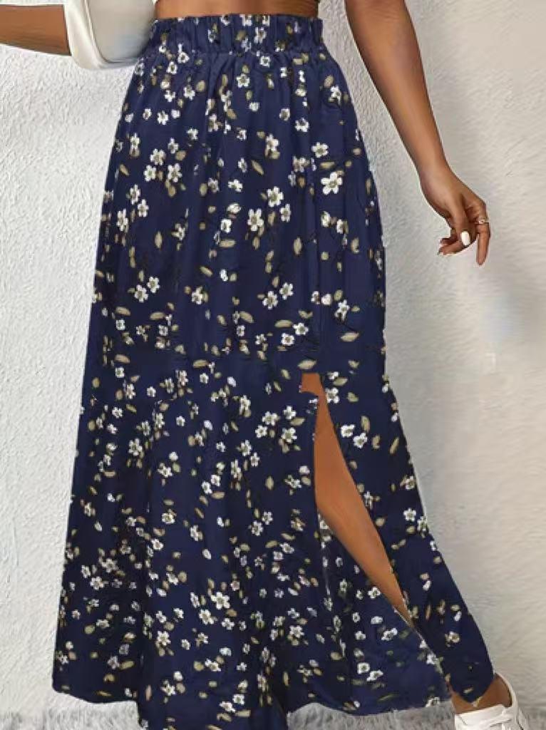 woman wearing navy blue floral print midi skirt with side slit, white sneakers and white handbag