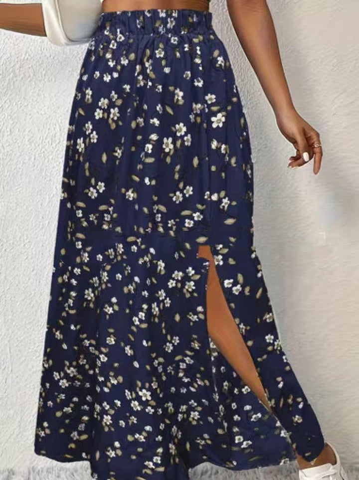 woman wearing navy blue floral print midi skirt with side slit, white sneakers and white handbag
