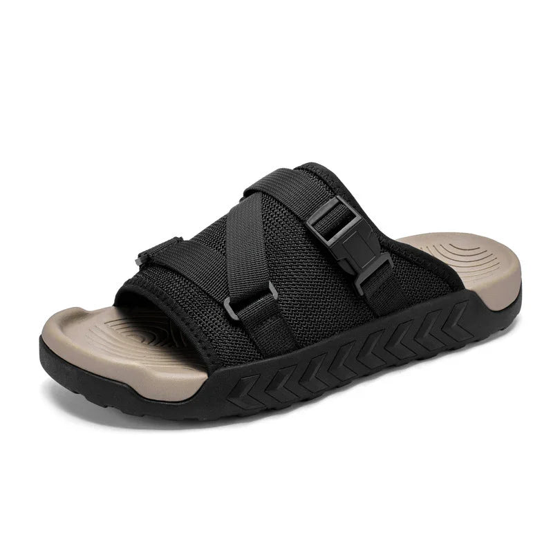 Black mesh slide sandal with adjustable straps and beige contoured footbed on white background