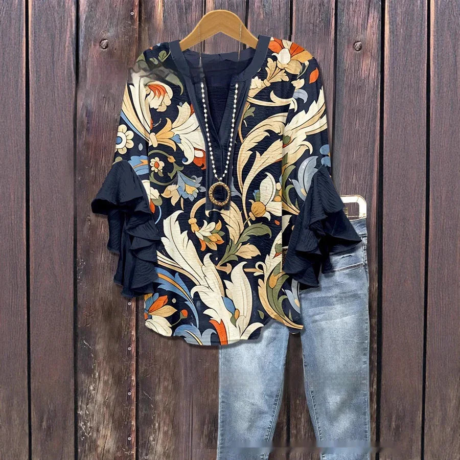 Floral print blouse with ruffled sleeves and necklace paired with light blue jeans on wooden background