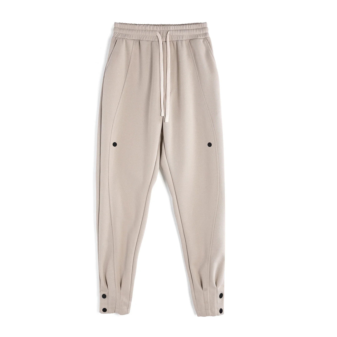 beige tapered drawstring jogger pants with black snap buttons and side pockets