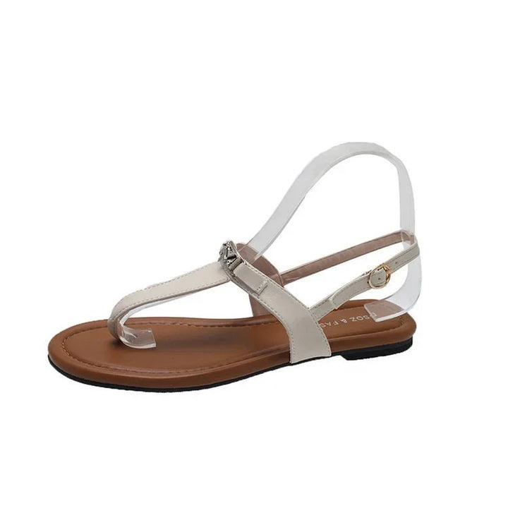 White leather flat thong sandal with ankle strap and brown cushioned footbed