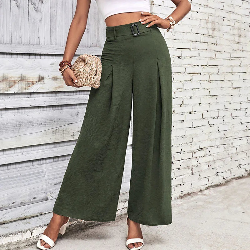 Woman wearing high-waisted olive green wide-leg pants with a belt, white crop top, and white heels