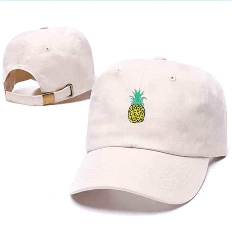 White baseball cap with embroidered yellow pineapple design and adjustable brass buckle strap