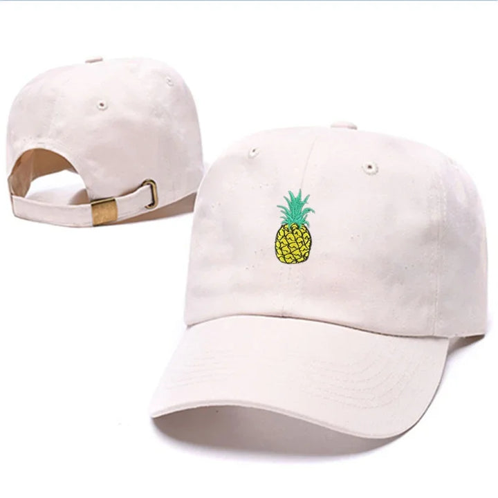 White baseball cap with embroidered yellow pineapple design and adjustable brass buckle strap