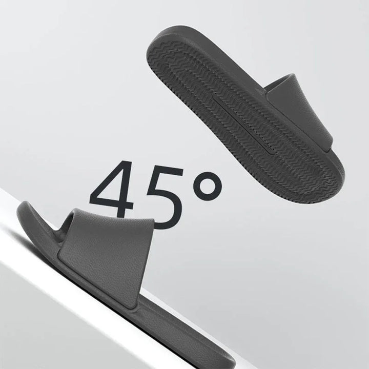 Gray slip-on sandals shown at 45-degree angle, featuring textured sole and simple design