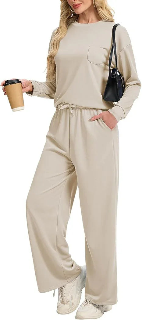 Woman wearing beige casual loungewear set with long sleeves and wide-leg pants holding coffee cup and black handbag
