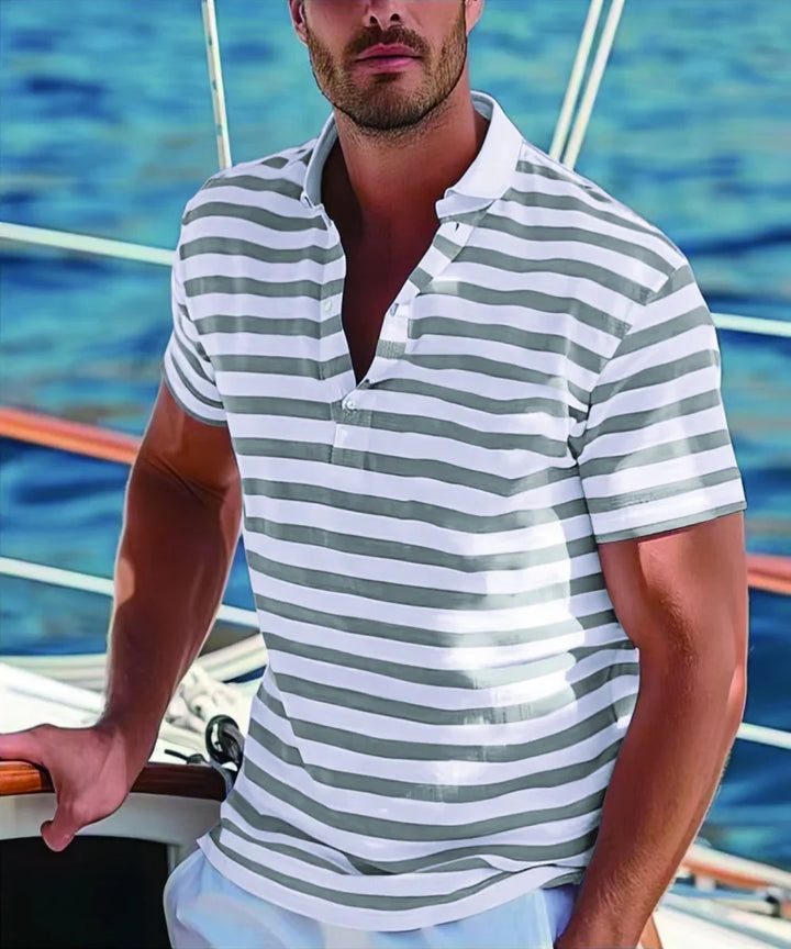 Man wearing gray and white striped polo shirt on a boat with blue water background