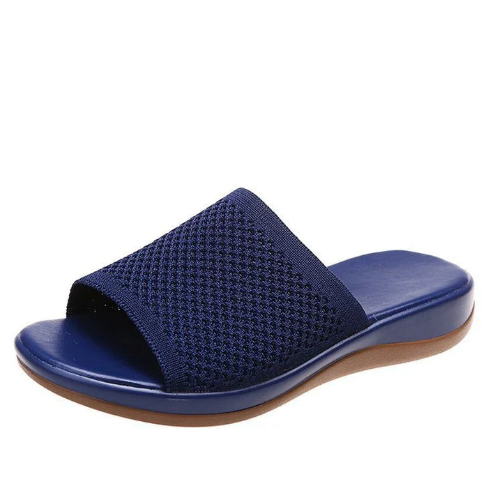 Navy blue open-toe slide sandal with textured fabric upper and brown sole