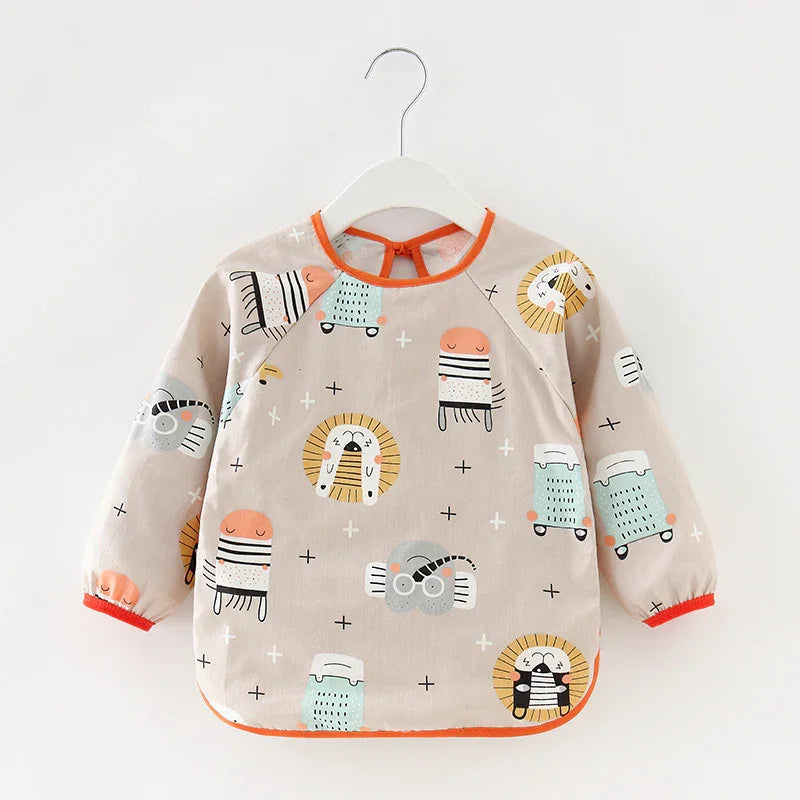 Beige baby bib with long sleeves and colorful animal cartoon prints, orange trim, hanging on white hanger