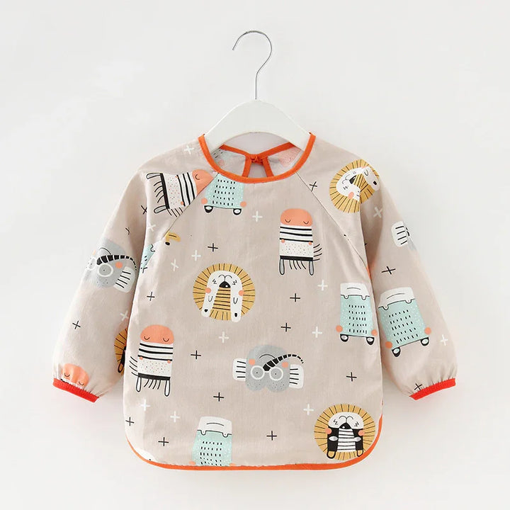 Beige baby bib with long sleeves and colorful animal cartoon prints, orange trim, hanging on white hanger