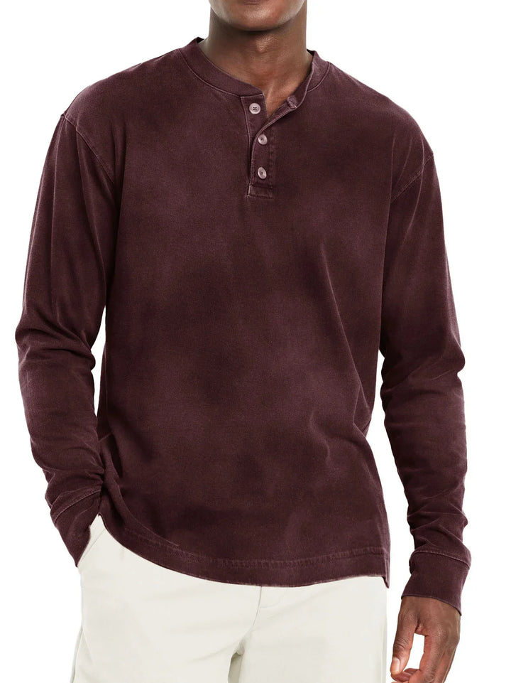 Man wearing a dark brown long-sleeve henley shirt with three buttons and beige pants