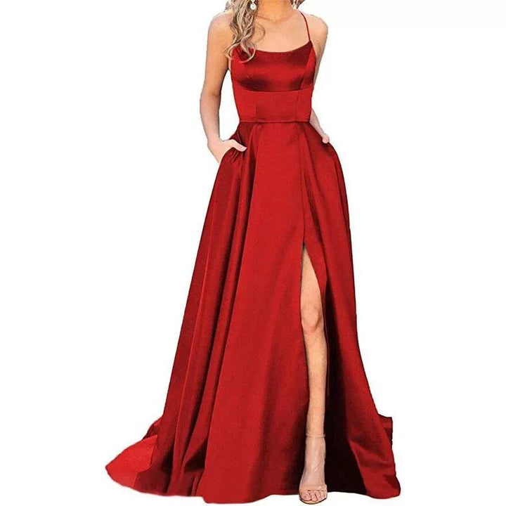 Woman wearing elegant red satin evening gown with spaghetti straps and thigh-high slit