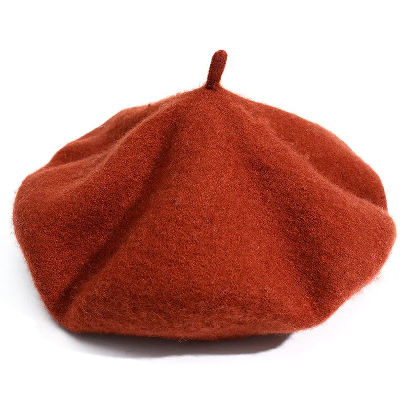 Rust orange wool beret with a small top stem on a white background