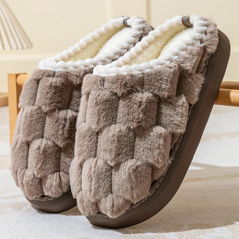 Pair of cozy brown faux fur slippers with plush white lining on beige carpet