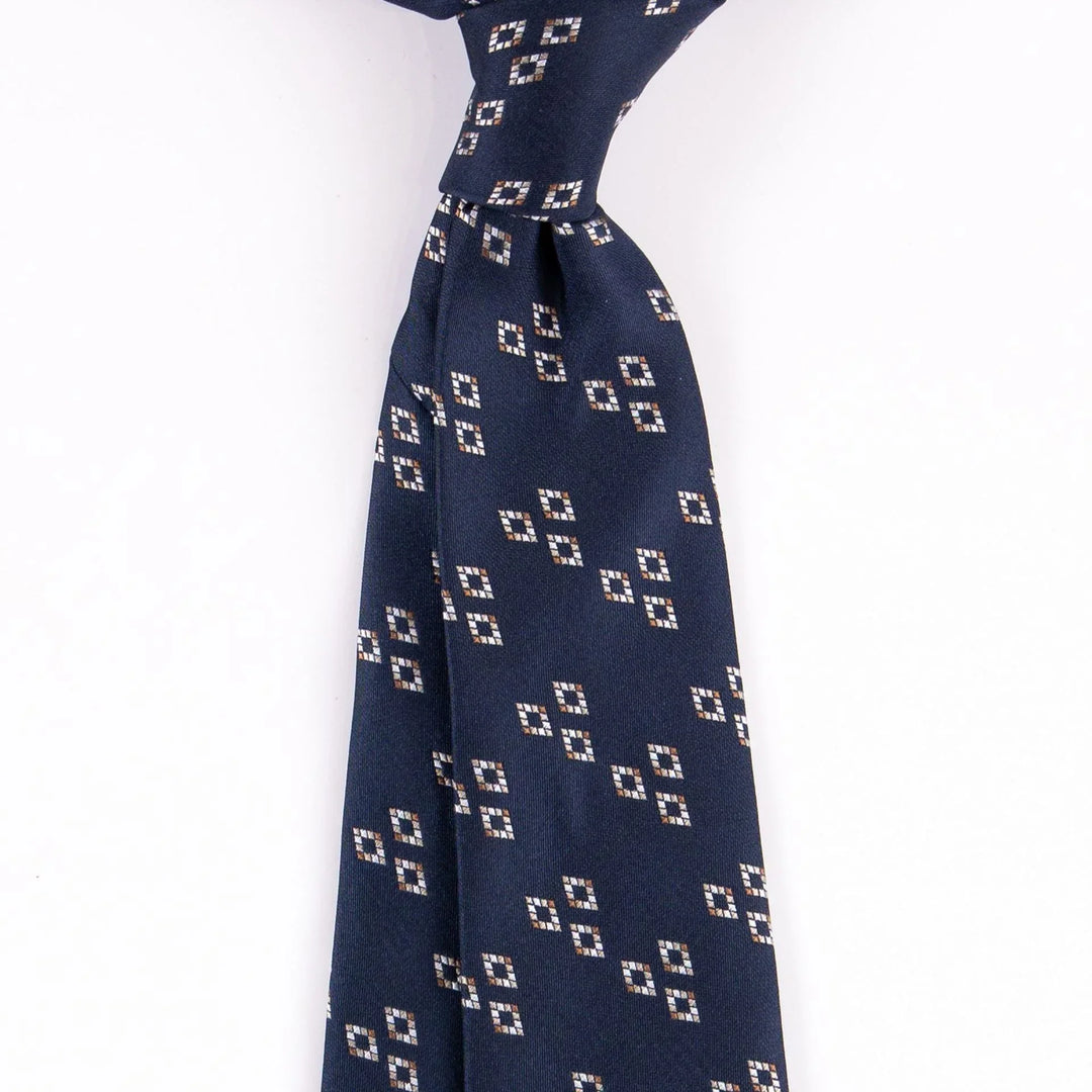 Navy blue necktie with beige and white geometric square pattern on white background