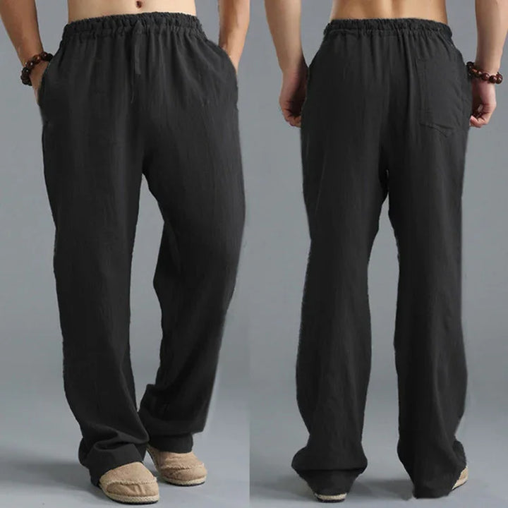 Black loose fit casual pants with elastic waistband shown from front and back on male model