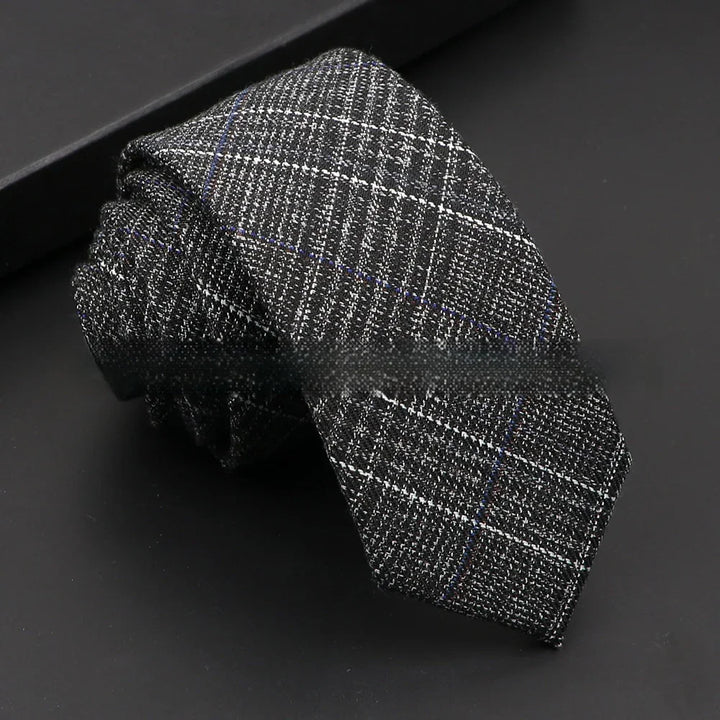 Black and gray checkered men's necktie with subtle blue lines on black background